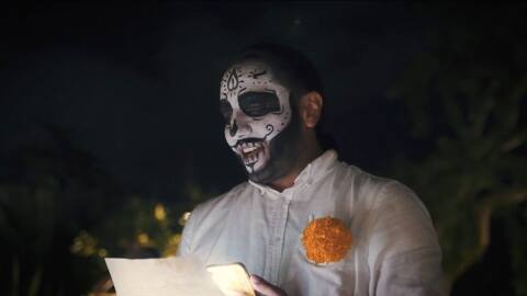 A person with face paint holding a paper during Hanal Pixán at Hacienda Xcanatun, Angsana Heritage Collection in Mexico