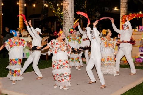 Dancers wear traditional embroidered dresses and white linen suits, moving in intricate steps to the upbeat rhythm of the jarana, a hallmark dance of Yucatan.