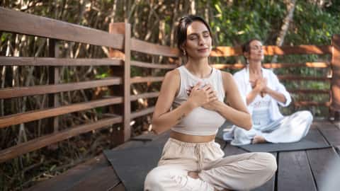 A woman engaged in a wellness exercise session under Banyan Tree Connections at Banyan Tree Mayakoba