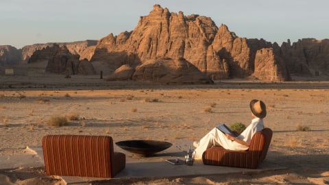 A man relaxing while looking at the sandstone formations of the desert